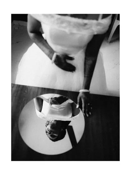 I often use creative angles to tell a deeper story. This black and white shot, using a mirror's reflection, captures a quiet moment of introspection for the bride, adding a layer of artistry and emotion to her wedding day story.