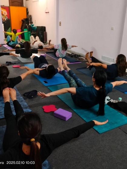 Building core strength is essential for a healthy back and stable practice. This group is engaged in a variation of Navasana, or Boat Pose, to activate their abdominal muscles.