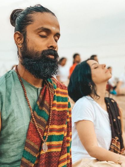 Students sit in meditation during an outdoor ceremony. The combination of sacred ritual and the natural elements creates a deeply grounding and spiritually charged experience.