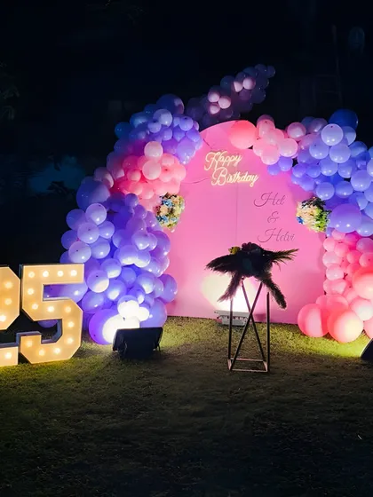 A vibrant outdoor setup for a 25th birthday party. I used a color palette of pink and purple balloons, a custom pink backdrop with a neon sign, and large marquee numbers to create a fun and festive atmosphere.