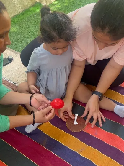 Here, a mother and grandmother work together with a child on a craft. My sessions welcome all caregivers, creating a supportive environment for the whole family to participate in the child's learning journey.