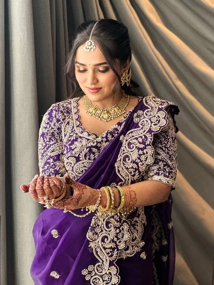 A candid moment showing Ruchita admiring her bangles. The makeup is designed to look beautiful from all angles, ensuring she is picture-perfect throughout her event.