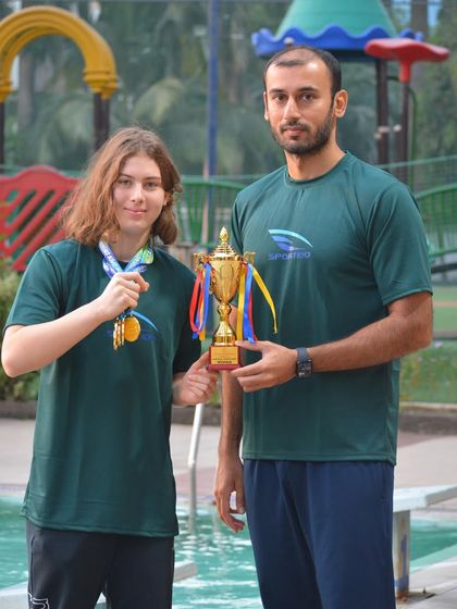 Champion Vivian Pellmar receives her trophy from Coach Virdhawal Khade. His experience competing at the highest level provides invaluable guidance to our team.
