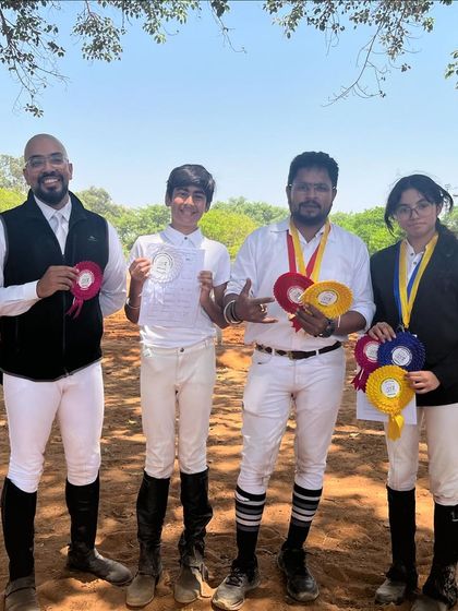 Four of our riders showing off their ribbons after a successful day. We celebrate every achievement, from clear rounds to podium finishes.