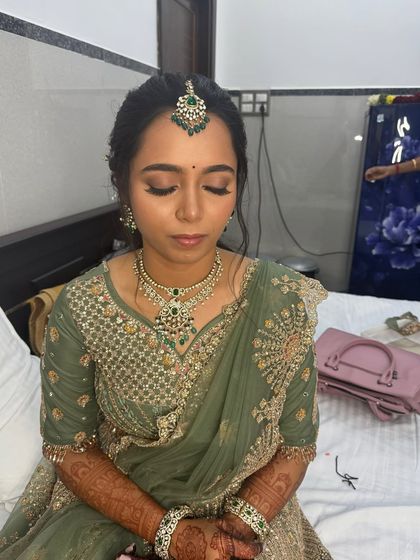 A close-up of Anitha's reception makeup with her eyes closed. The soft, neutral eyeshadow and defined liner create a timeless and elegant look.