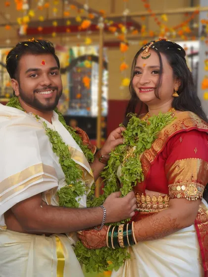 A happy moment between the bride and groom during their temple wedding. Both are dressed in traditional South Indian attire.