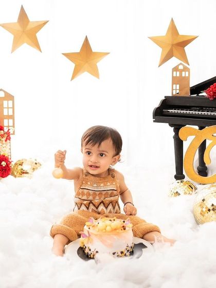 A starry night themed cake smash for a special one-year-old. The combination of clouds, stars, and a piano prop makes for a dreamy birthday celebration.