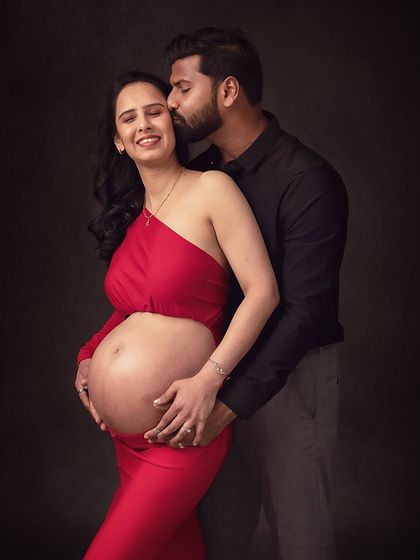 A happy, loving kiss on the cheek. The joy and excitement of the parents-to-be are palpable in this image.
