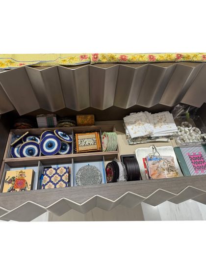 A drawer for table decor and accessories, including coasters and napkin rings, all sorted into compartments.