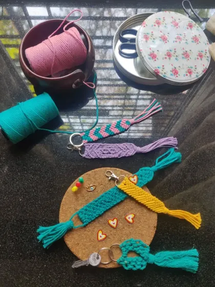 A little peek at our workstation where we create our macrame bag charms and keychains. You can see the different colors and patterns we love to experiment with.