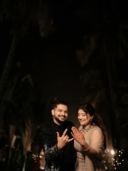 A fun and cool portrait from the after-party. The groom throws up a rock-on sign while the bride shows off her henna, capturing their personalities and the relaxed vibe of the evening.