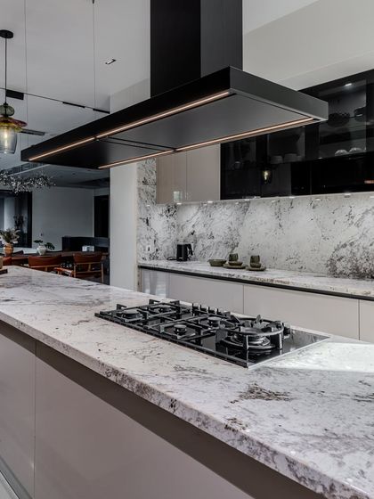 A detailed shot of the Brazilian granite countertop, showing its unique veining and texture. This natural stone adds a layer of organic beauty to the highly modern design.