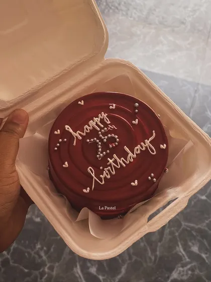 A rich, glossy red bento cake for a 25th birthday, with delicate white piping and heart details.