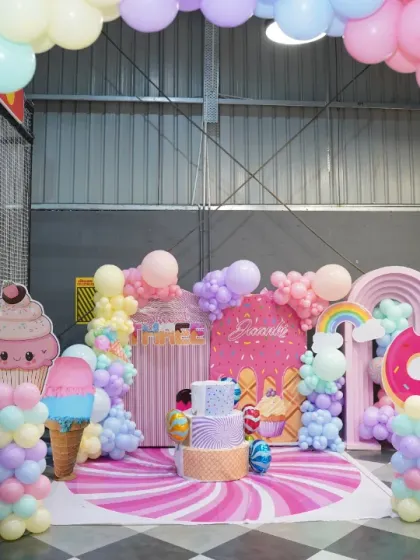 Another view of the spectacular candy-themed photo booth area, framed by a massive pastel balloon arch. It's the perfect spot for birthday photos.