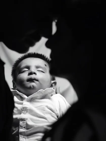 A silhouette-style black and white photo of parents and their newborn, creating a powerful and artistic family portrait.