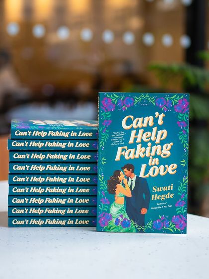 A stack of my sophomore novel, "Can't Help Faking in Love." The cover is just as vibrant and fun as the story inside.
