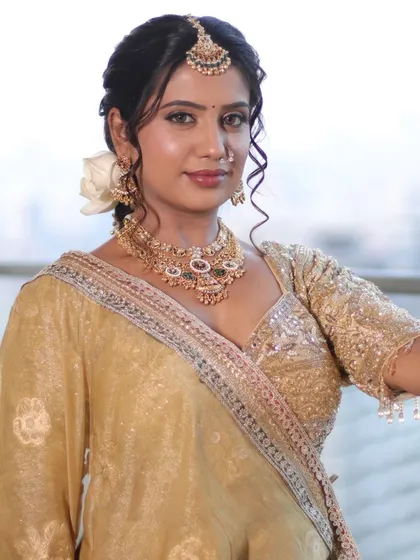 A classic portrait of the bride in her golden lehenga. The makeup is soft and timeless, with a focus on enhancing her natural features for an elegant bridal look.
