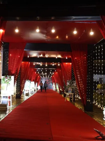 We believe the event experience should start at the entrance. A dramatic, fully draped red carpet walkway like this, illuminated with fairy lights, creates an immersive and high-impact welcome for guests at a product launch or celebratory dinner.