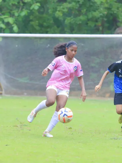 Taking on a defender one-on-one, demonstrating confidence and skill on the ball.