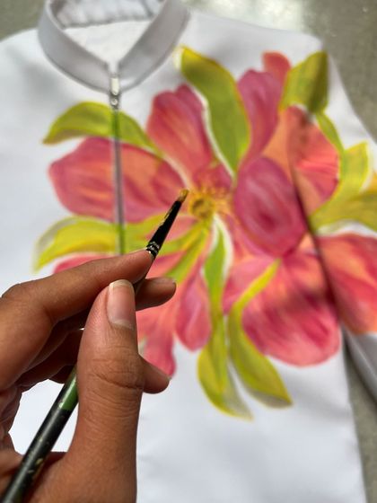 The client wanted a flower design to coordinate with the bride's neon green and pink outfit. I painted this vibrant yet subtle floral piece on the groom's jacket, creating a beautiful connection between their wedding attire.