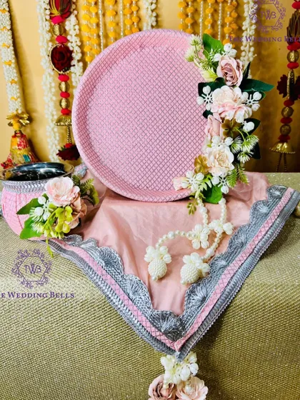 This pastel pink floral thali set is soft, elegant, and timeless. The delicate flowers and pearl details are perfect for a modern yet traditional look.