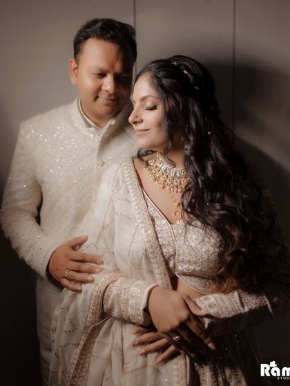 A warm and affectionate portrait of the engaged couple. The groom's gentle embrace and their happy expressions convey a sense of comfort and deep love.