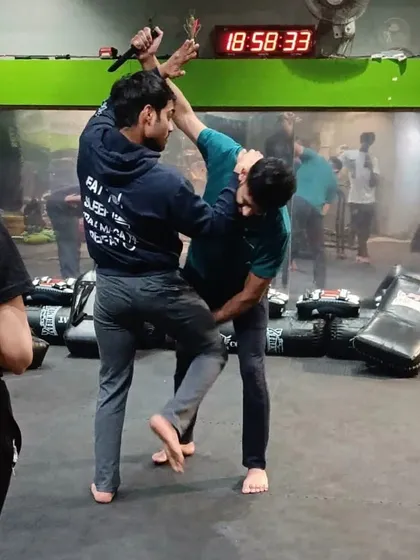 This is a knife defense drill in action. The focus is on simultaneous block and counter. As one student attacks, the other practices controlling the weapon arm while delivering a disabling knee strike to the groin. This is how you train for survival.