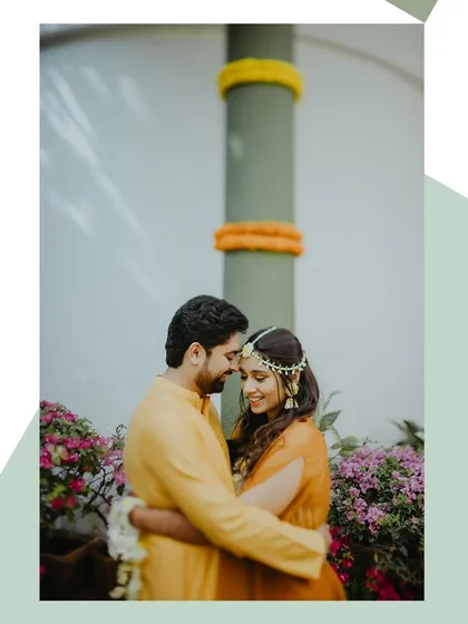An intimate portrait of the couple embracing during their Haldi ceremony, surrounded by flowers.