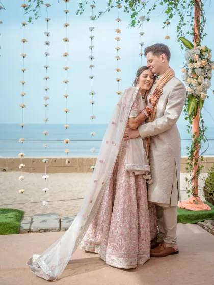 A joyful, candid shot of a couple sharing a laugh during their beachside wedding. The natural light and relaxed embrace showcase the authentic, happy moments I strive to capture throughout the wedding day.