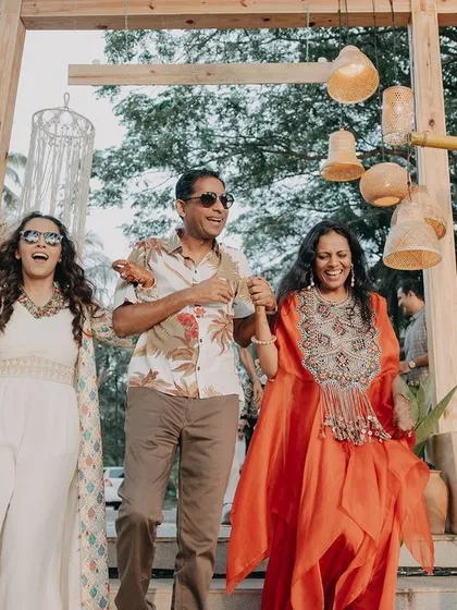 The bride's grand entrance with her parents. This shot captures the pride and joy on their faces as they walk together, a beautiful and emotional moment from the wedding day.