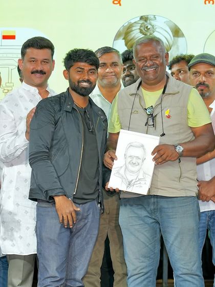 Another angle of me presenting the live sketch to director T.S. Nagabharana at a Kannada cultural event.