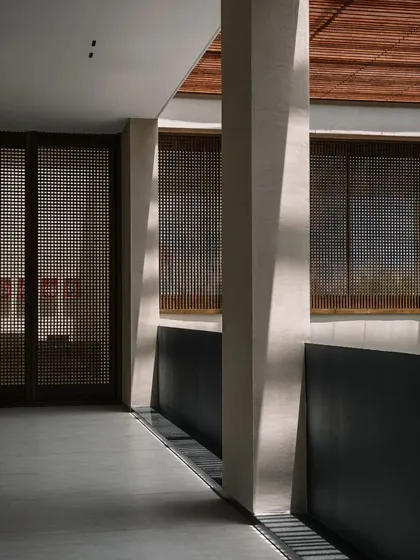 The corridors are designed to be experiences in themselves, with changing patterns of light and views of the central courtyard. The use of wooden screens provides privacy while maintaining a connection to the outdoors.