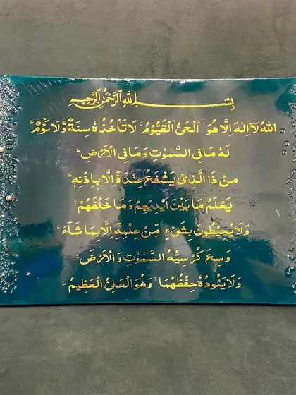 An elegant Ayat ul Kursi plaque in a rich emerald green and gold color scheme. The borders are adorned with a cascade of crystals and pearls, adding a touch of luxury to the sacred verse.