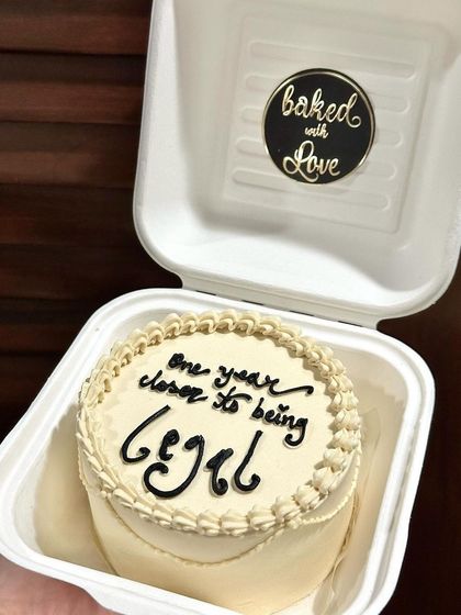 A simple and elegant bento cake celebrating being 'one year closer to being legal'. The clean design and classic piping make it a timeless choice.