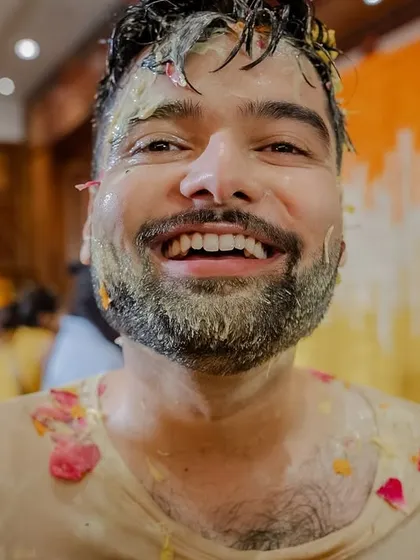 A close-up of the groom, laughing and completely covered in haldi. These are the fun, candid portraits that tell the story of the day.