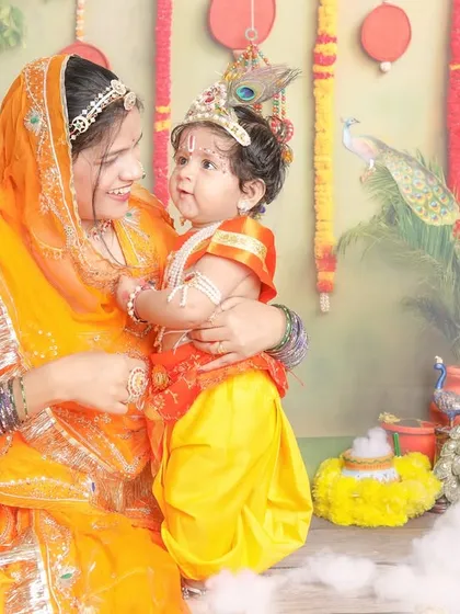 A loving gaze between mother and son, dressed in beautiful traditional attire for a Janmashtami photoshoot.