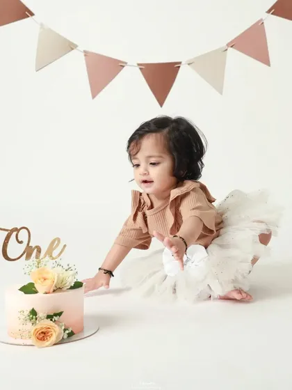 The moment of truth! The birthday girl tentatively reaches for her cake, ready for the smash.