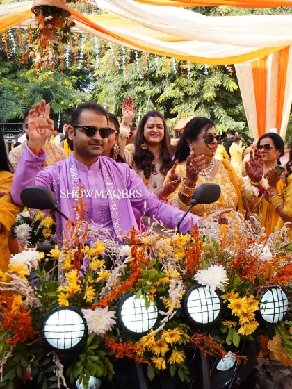 The groom makes a grand entrance on a flower-decorated ATV, waving to guests and adding a modern twist to the traditional Haldi ceremony.