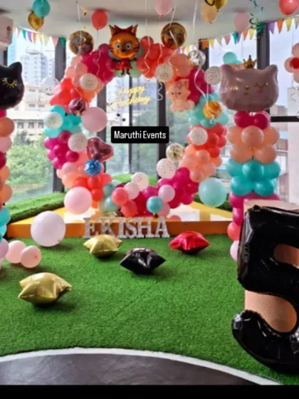 An adorable cat-themed party. The circular balloon arch is topped with cute cat-shaped balloons, and the setup includes cat-faced balloon columns.