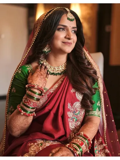 Serving major styling goals for modern Maharashtrian brides. The combination of a red saree, green blouse, and flawless makeup is simply breathtaking.