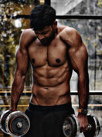 Building Traps with Shrugs. A photo demonstrating a dumbbell shrug, a key exercise for developing the trapezius muscles.