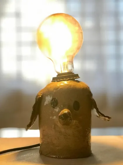 A close-up of a finished dog-shaped lamp, glowing warmly. This piece, made in our one-day workshop, shows the incredible results you can achieve.