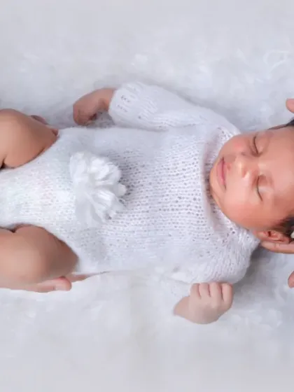 Held safely in her parents' hands, this little one is the center of their universe. This artistic shot symbolizes the love and support surrounding a new baby.