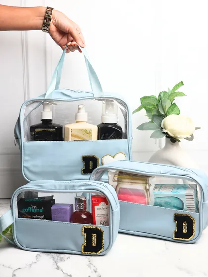 Our set of 3 clear-view wash bags in a lovely powder blue. Each bag is personalized with a black and gold chenille "D" patch, making it a stylish and practical set for travel.