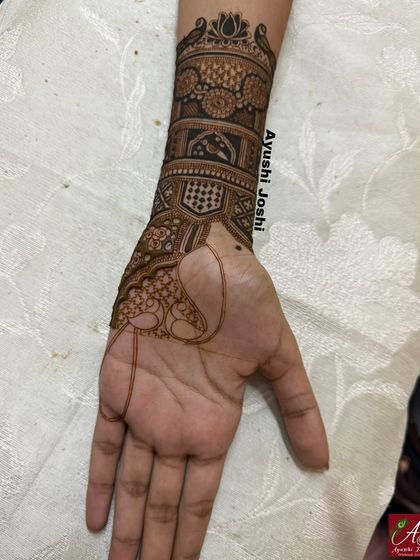 The beginning of an engagement design, showing the lower part of the hand and wrist work. You can see the outline for the main peacock motif on the palm.