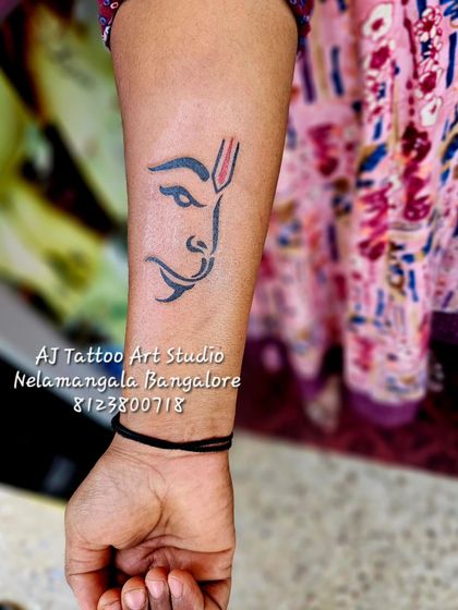 A minimalist Hanuman face tattoo on the forearm, a modern take on a classic spiritual design.