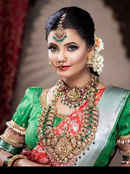 You can never go wrong with the auspicious combination of green and red. This traditional silk saree with its vibrant green puffed-sleeve blouse is a classic choice for any South Indian wedding ceremony.