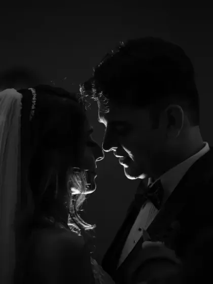 A dramatic, rim-lit silhouette of the couple. This artistic black and white shot is perfect for creating a moody and romantic wedding portrait.