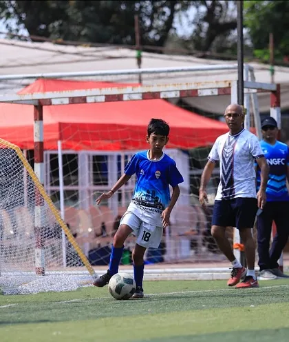 A young player focuses on the ball at his feet, ready to make his next move.