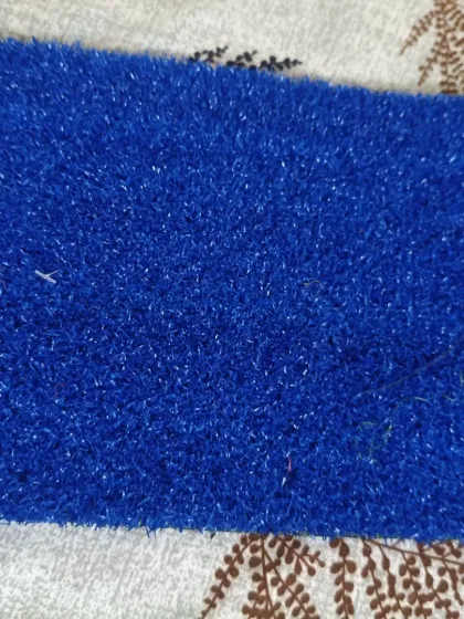 A close-up of the 15mm sports-grade turf in a solid blue color. This is often used for tennis courts, multi-sport areas, or branded event spaces.